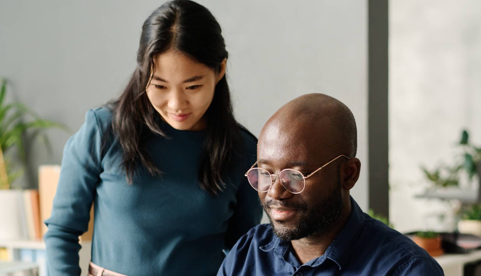 A man and woman discuss their finances while looking at a laptop