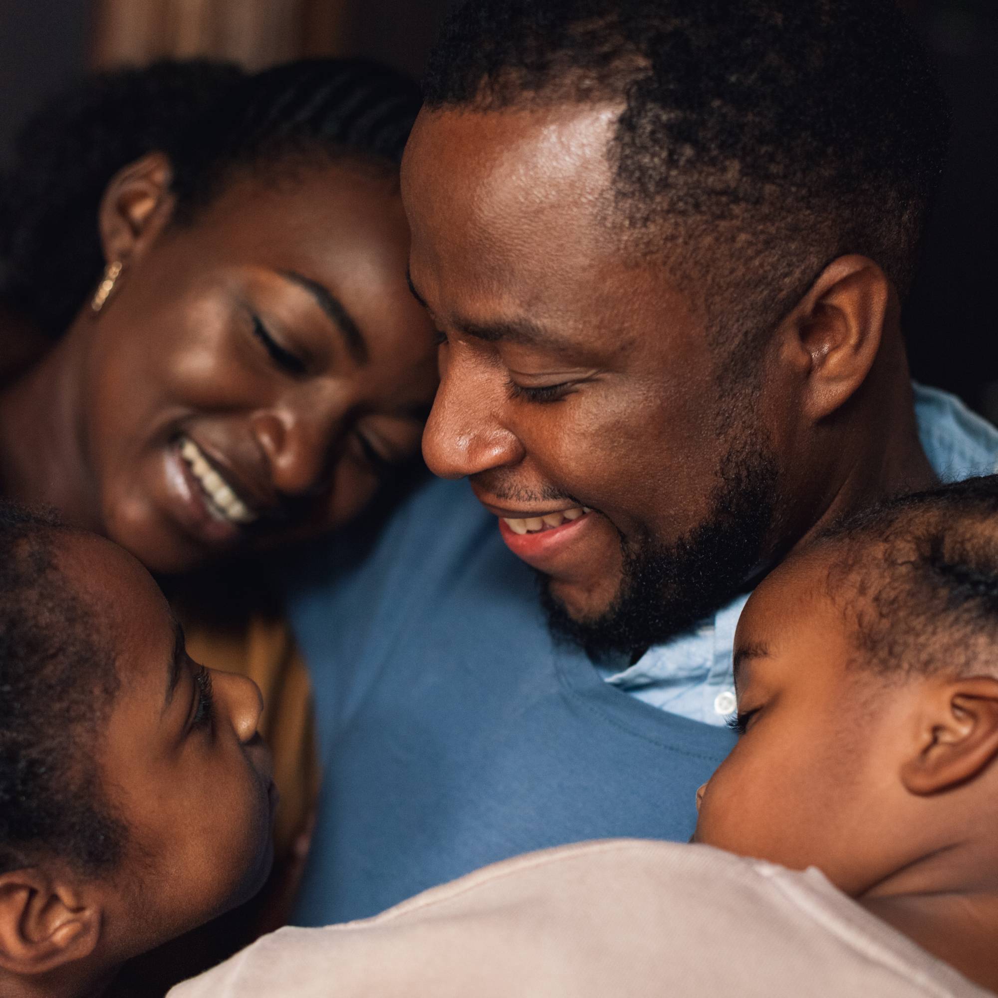 A mum and dad share a family hug with their two children
