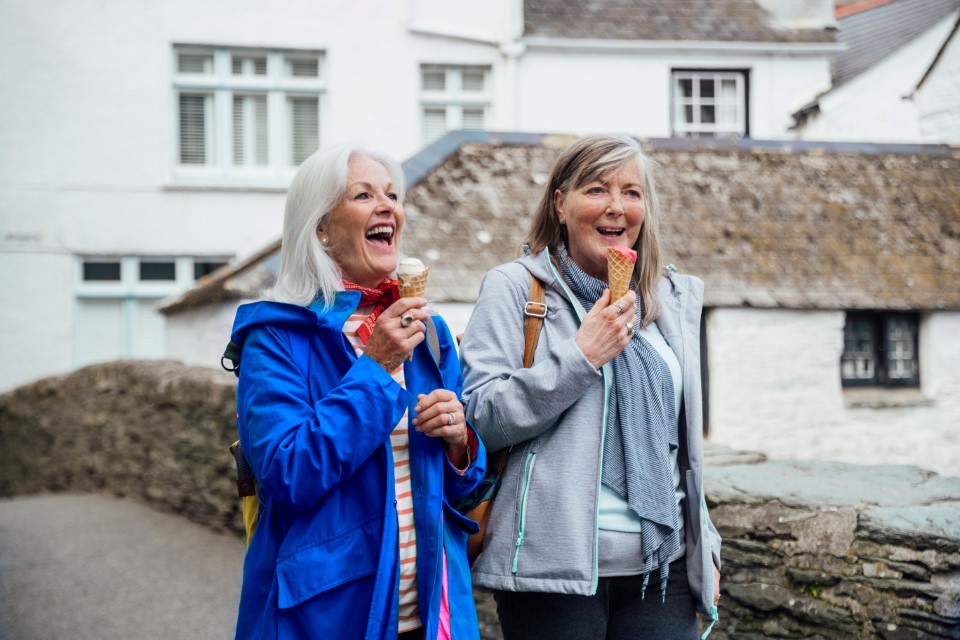 A picture of two ladies walking outside eating an ice cream