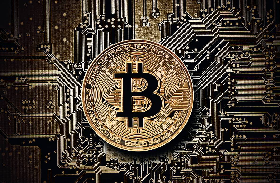 An illustration of a golden bitcoin coin sitting on top of circuit boards