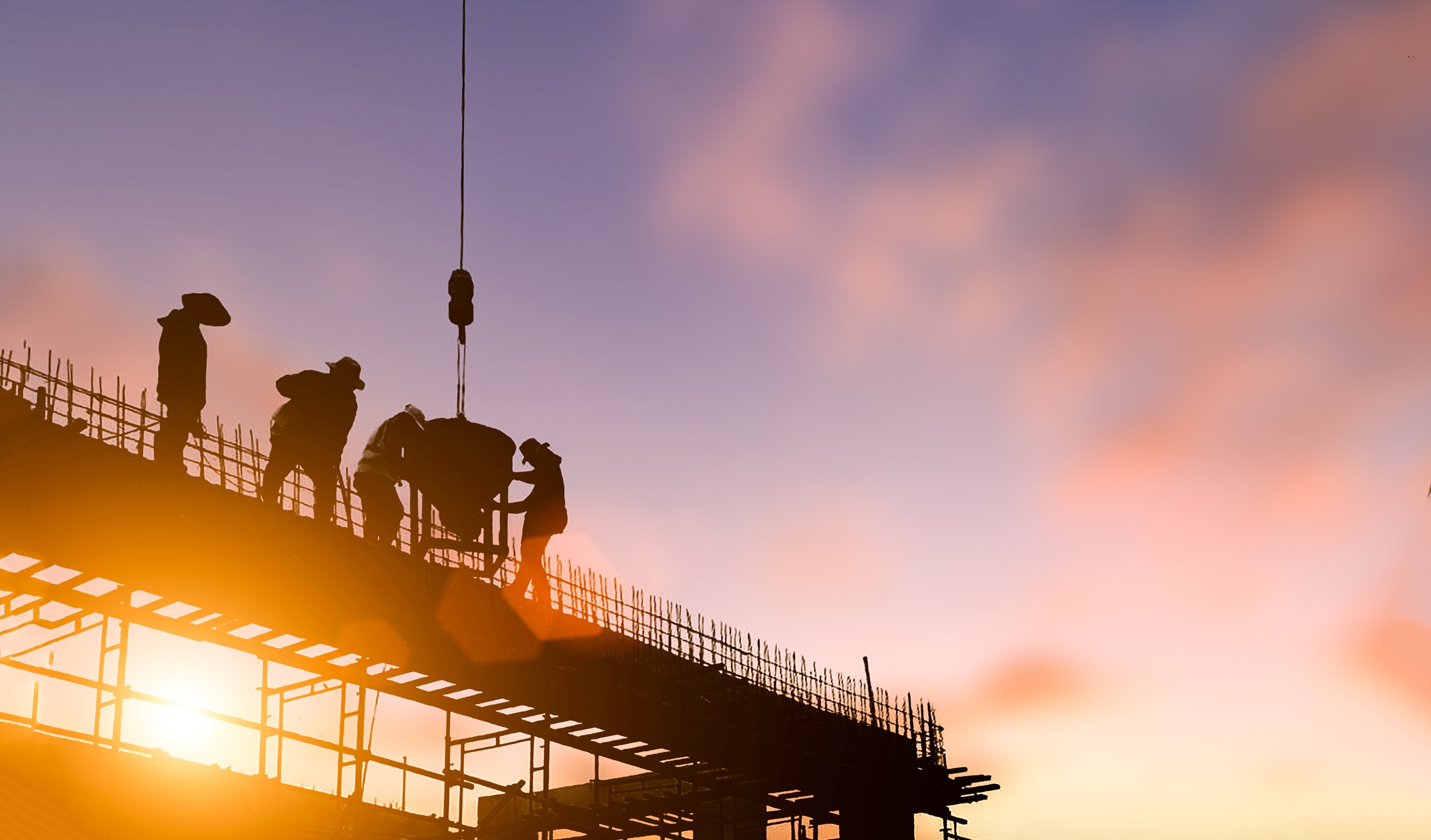 Construction workers at sunset