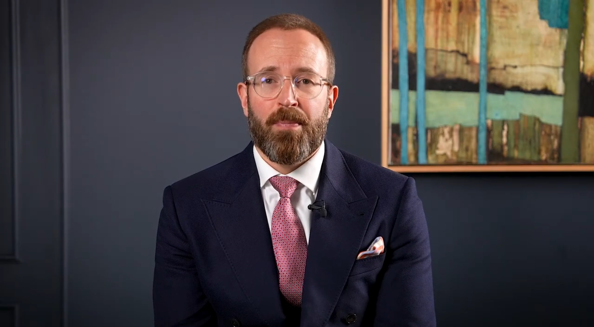 A still of a besuited Ed Smith speaking in a video update