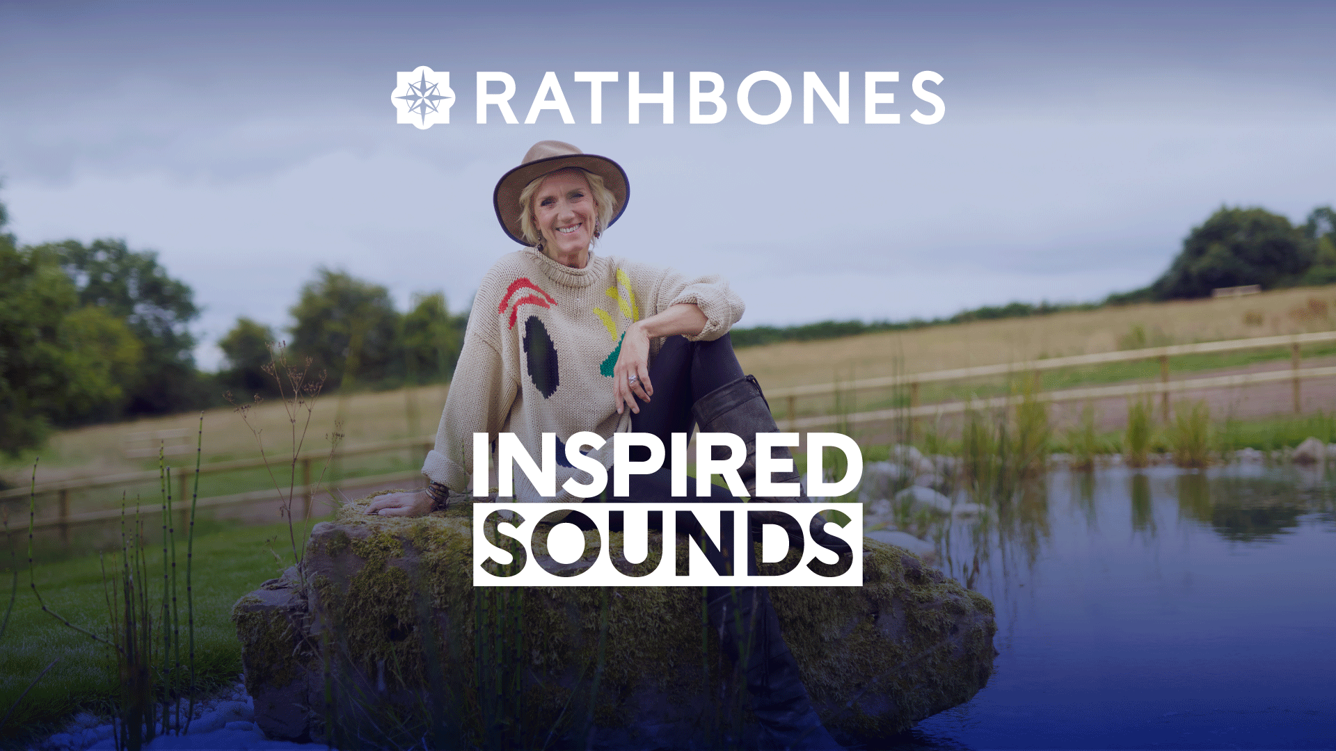 Laura Tenison MBE of Jojo Maman Bébé and Wonderful Escapes sits on a rock in the countryside, smiling at the camera