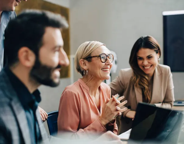 A lady laughs with her colleagues during a meeting