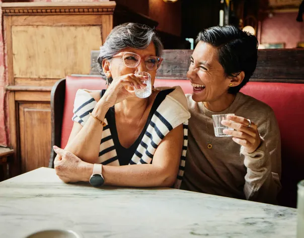 2 friends laughing in a cafe