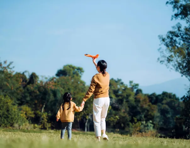 Mother and daughter flying a kite in a park