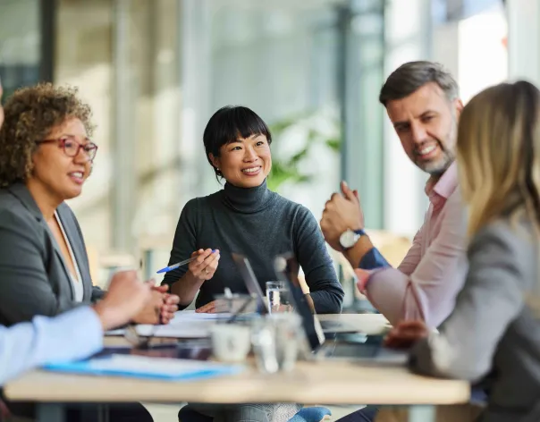A group of colleagues discuss a topic together in the office