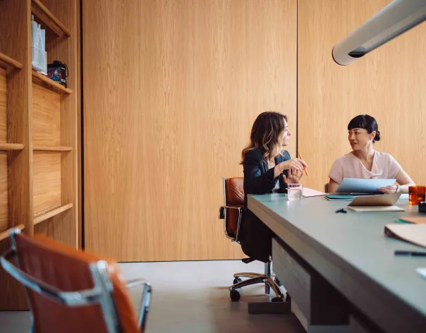 An adviser talks to their client in a large office