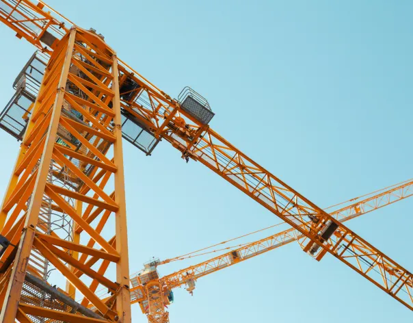 Looking upwards at yellow cranes operating in the skyline