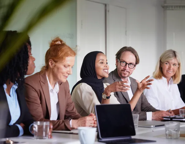 A group of colleagues discuss a topic together in the office