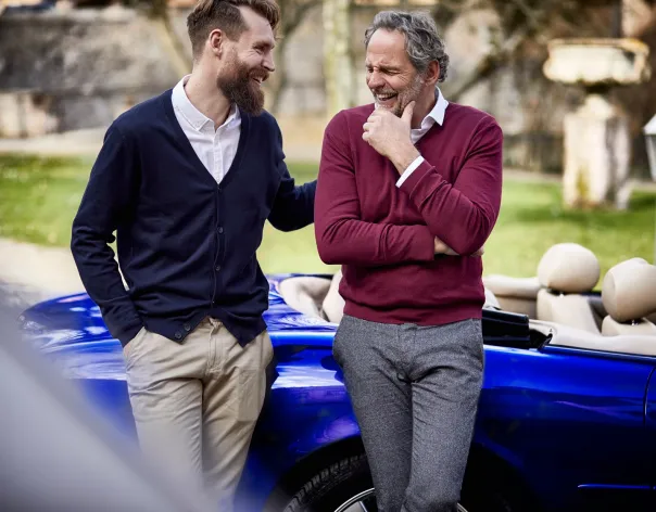 Two individuals in conversation beside a car, illustrating long‑term financial planning and the importance of preparing for retirement.