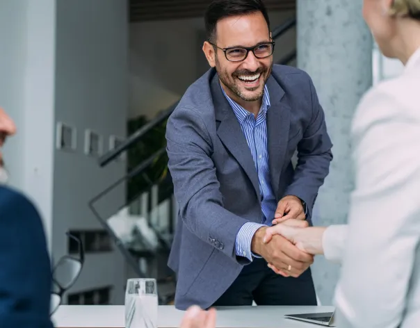 Handshake across a desk after a retirement income planning discussion