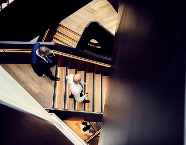 Looking down on Rathbones colleagues walking up and down a central stairwell in an office