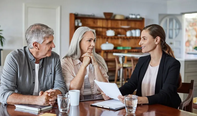 A couple meets with their financial advisers at the kitchen table
