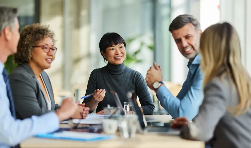 A group of corporate workers meet to discuss a topic