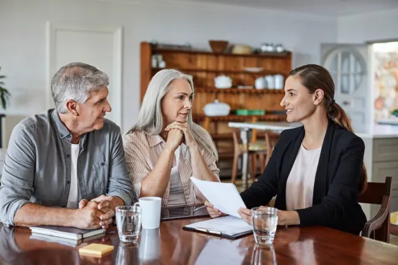 A couple meet their financial adviser at the kitchen table