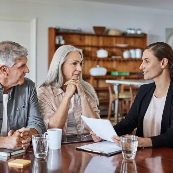 An adviser meeting with a middle-aged couple in their home