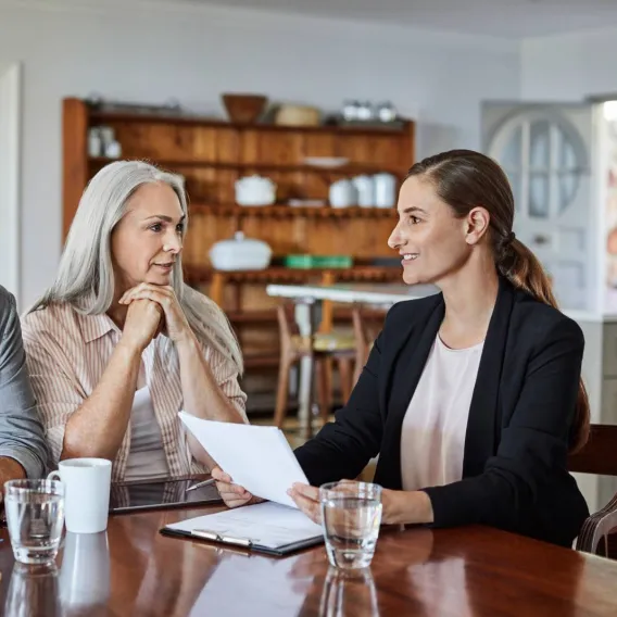 A couple meet their financial adviser at the kitchen table