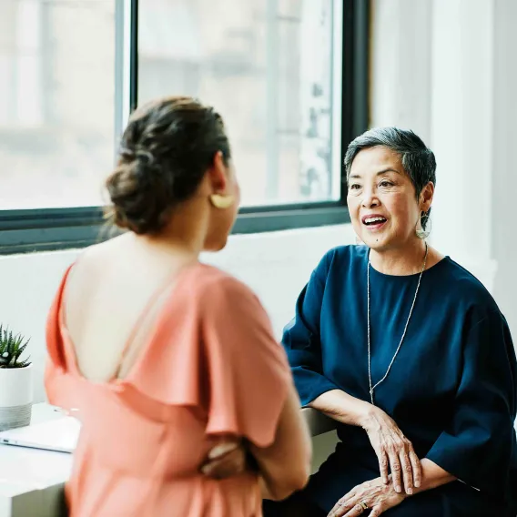 A pair of women in a garden supporting each other