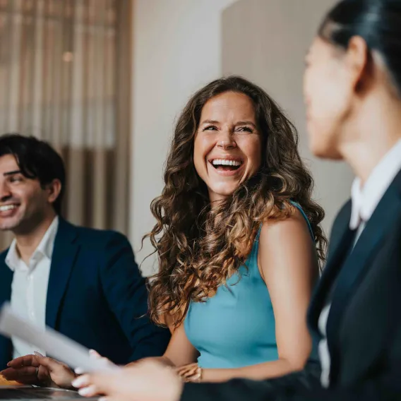 A group of professionals laugh while working together on a project