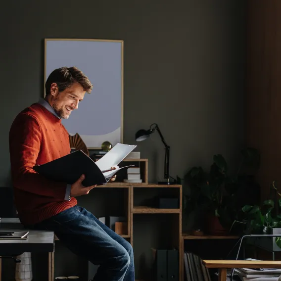 A man in his office reads a file