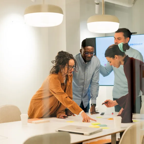Charity trustee stood around a table discuss topics related to charity investment