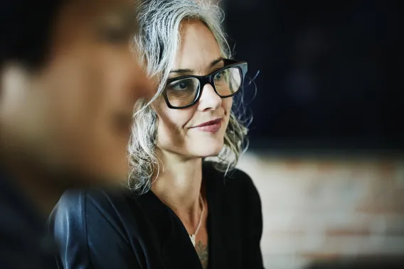 A lady wearing glasses sat down at a charity trustee event