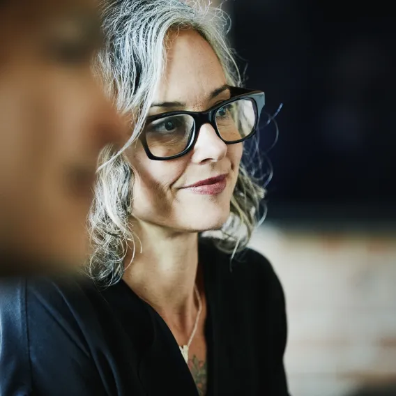A lady wearing glasses sat down at a charity trustee event