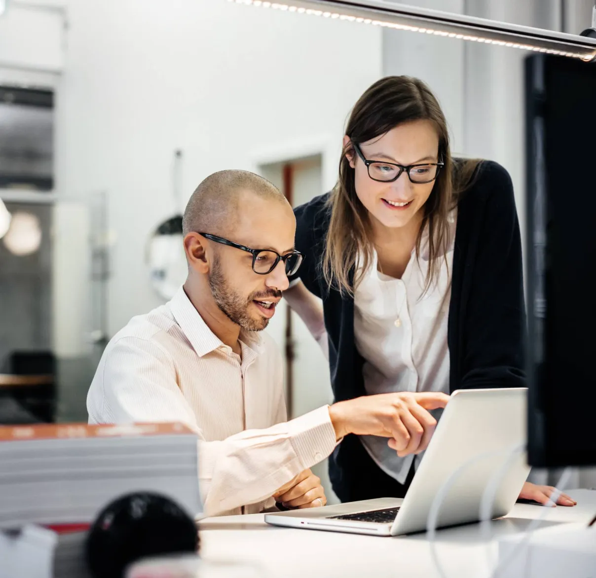 Two financial advisers look at a laptop together