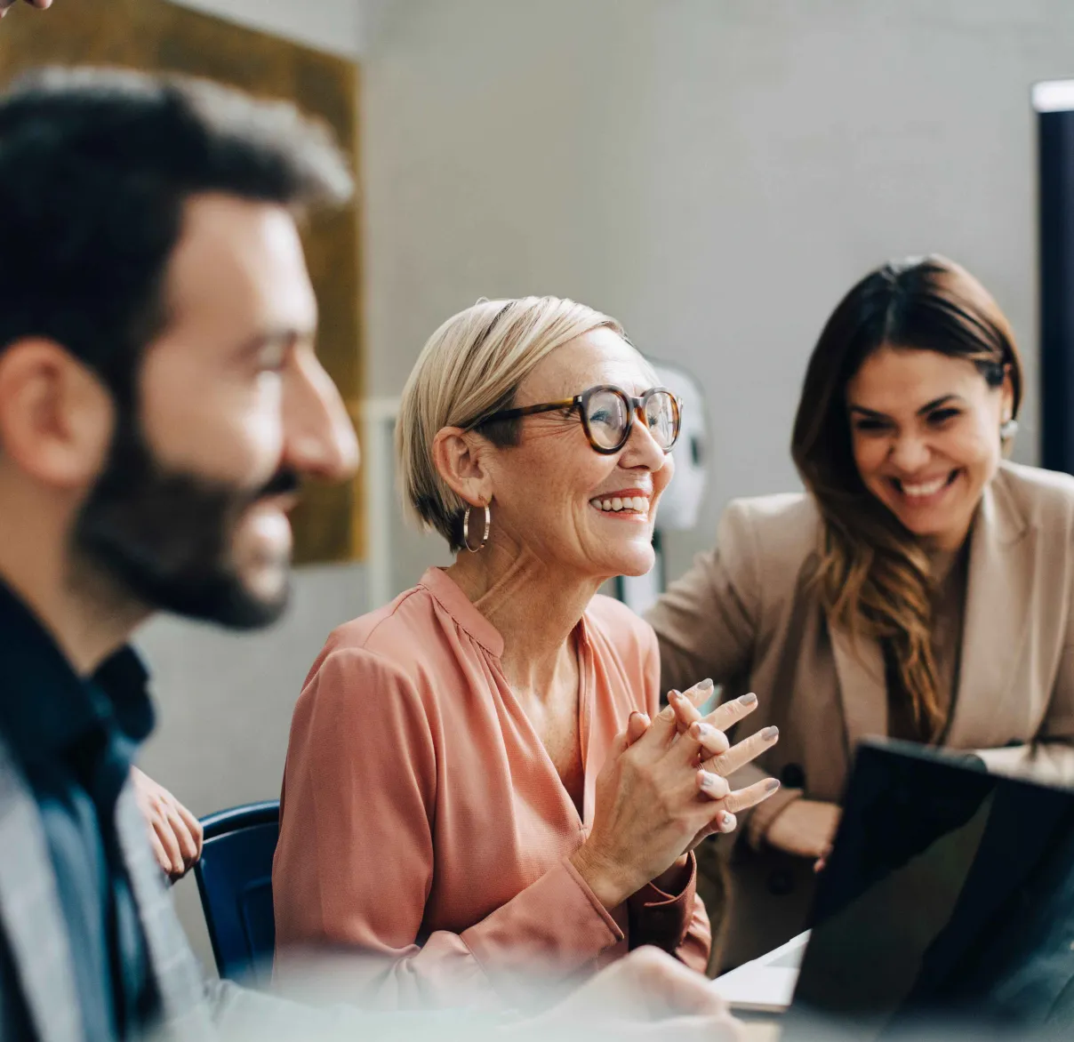 Four work colleagues laugh while working together