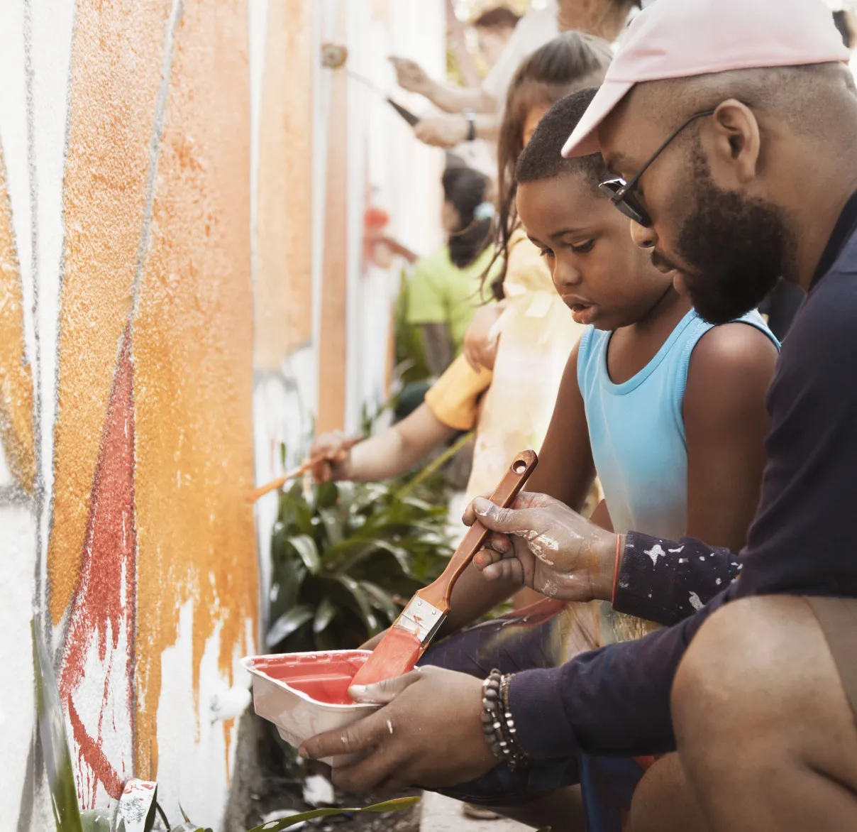 Volunteers paint a community wall with lots of colour