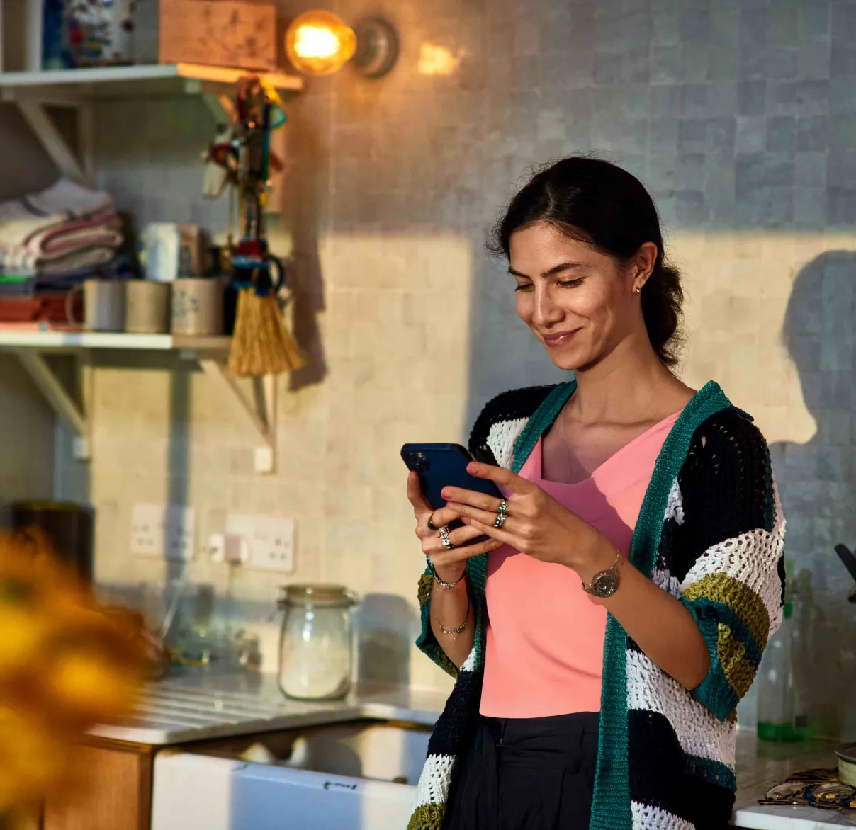 Young woman looking at her phone in kitchen