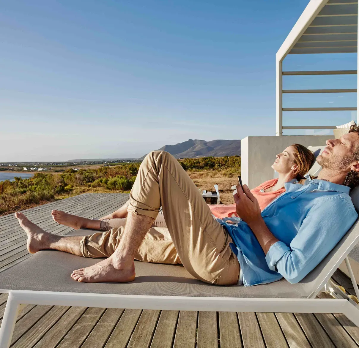 Man and woman lying on sun bench