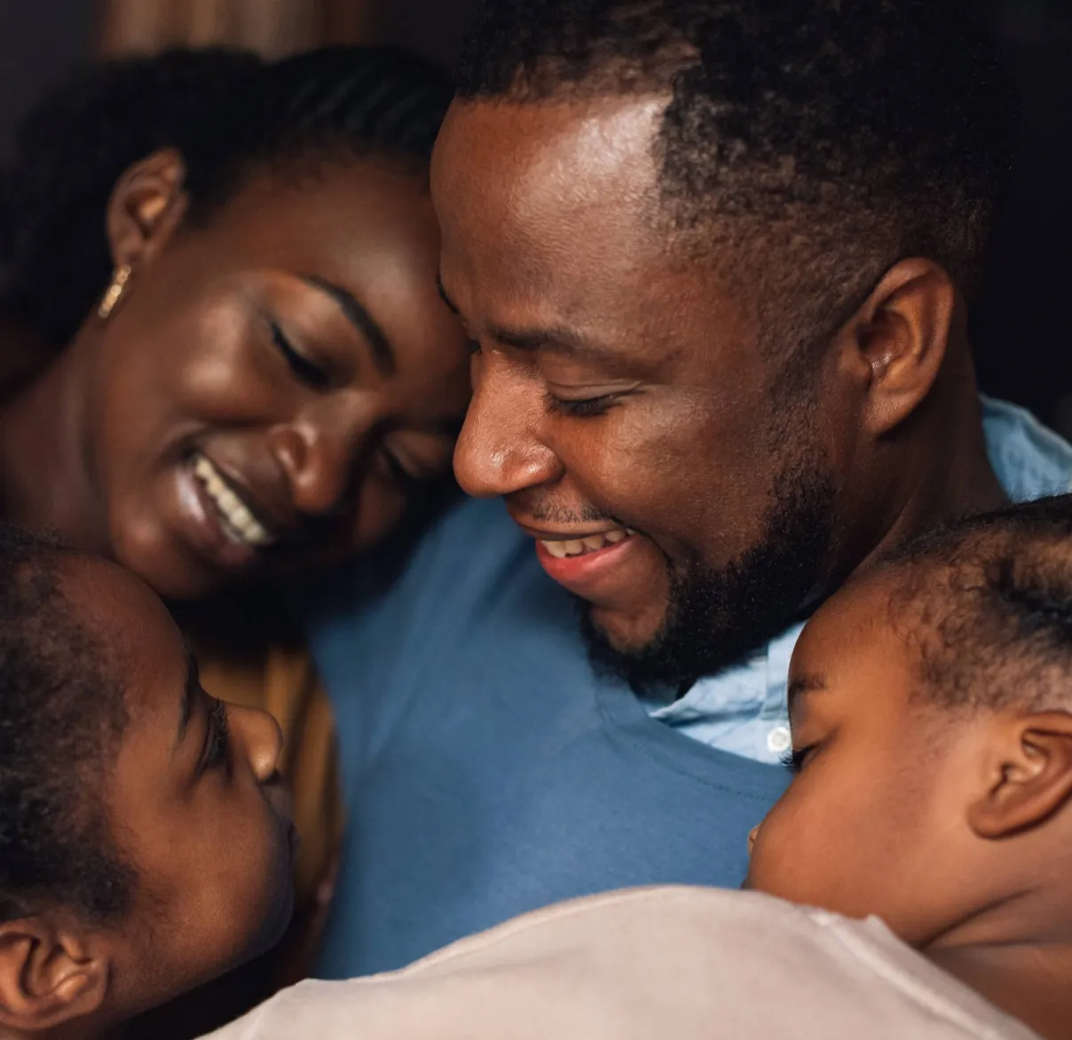 A mum and dad share a family hug with their two children