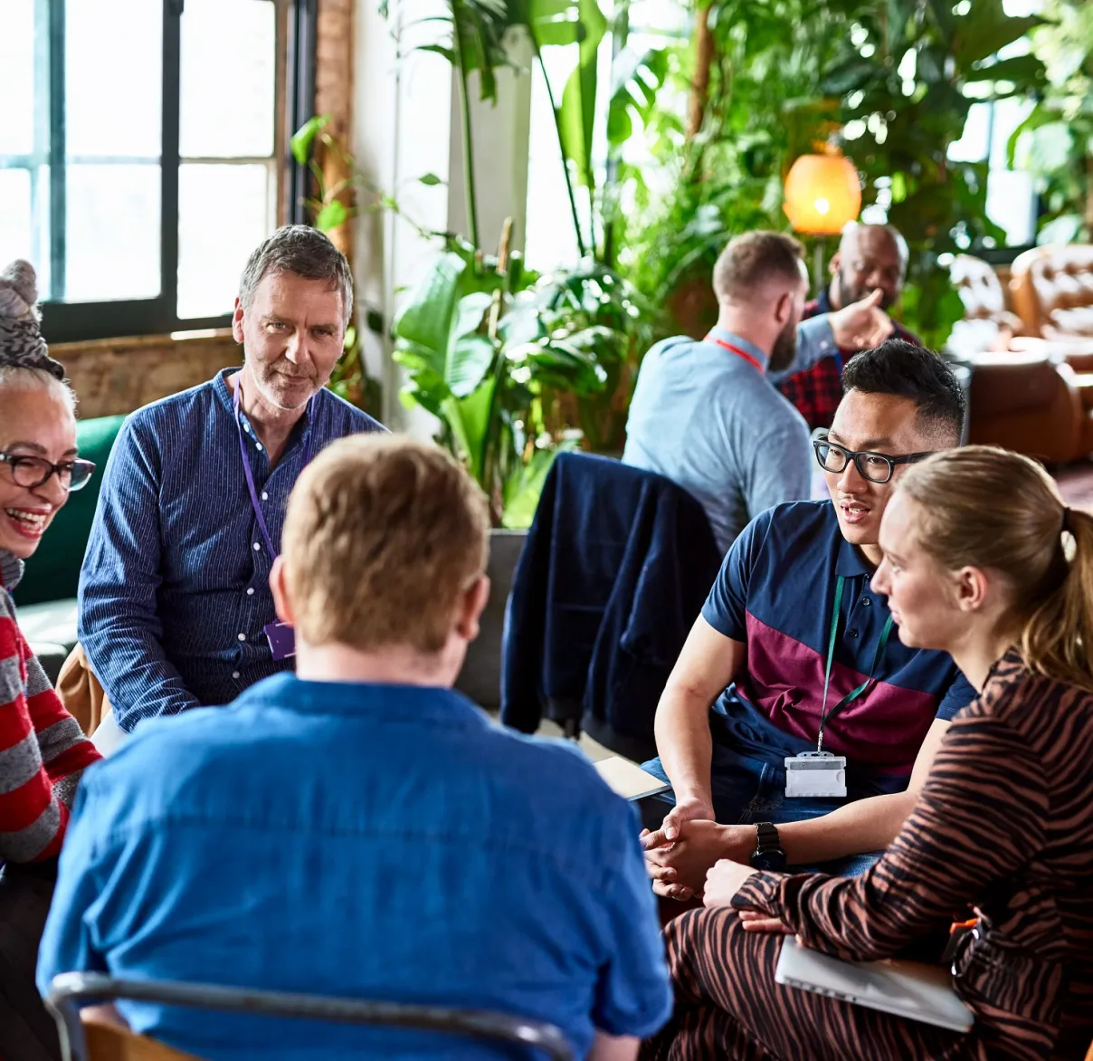 A group of charity trustees gathered in a circle discussing investment and wealth management solutions