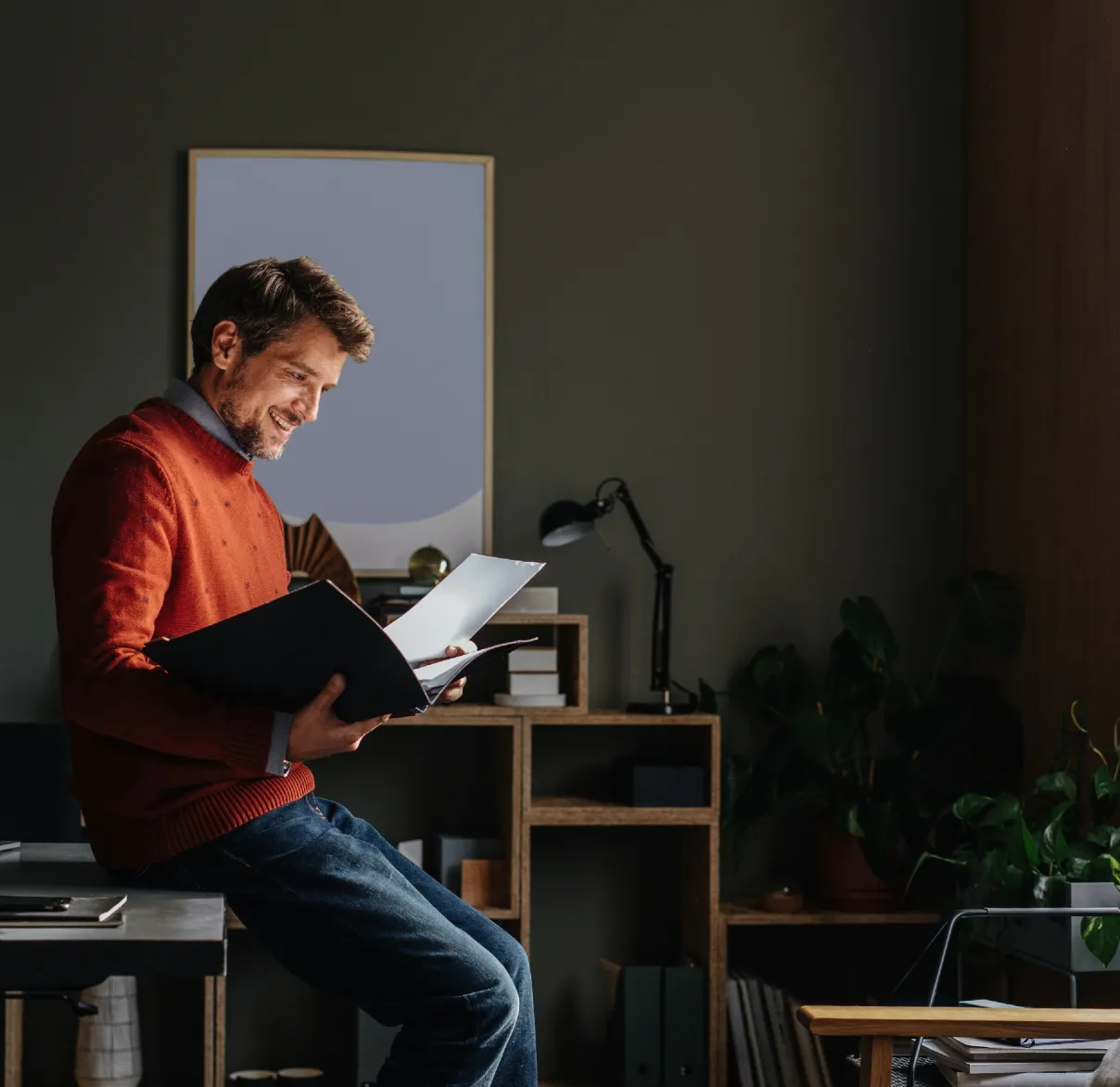 man reading a file in his home office