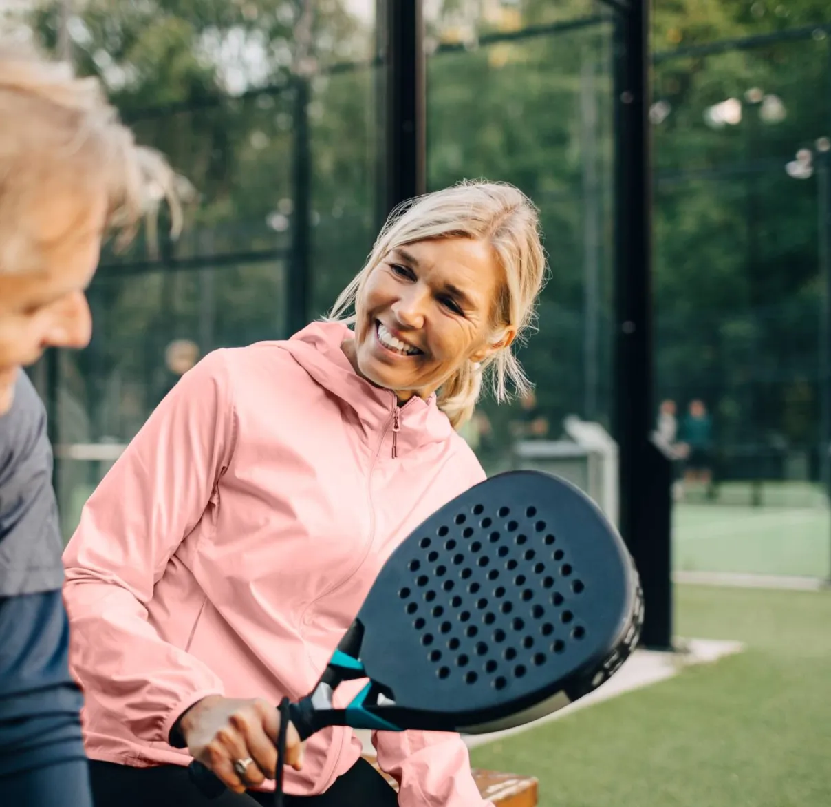 A couple laugh together after taking time out of their day for a game of padel