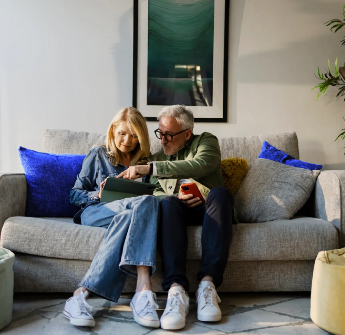 retired-couple-relaxing-on-sofa-looking-at-ipad