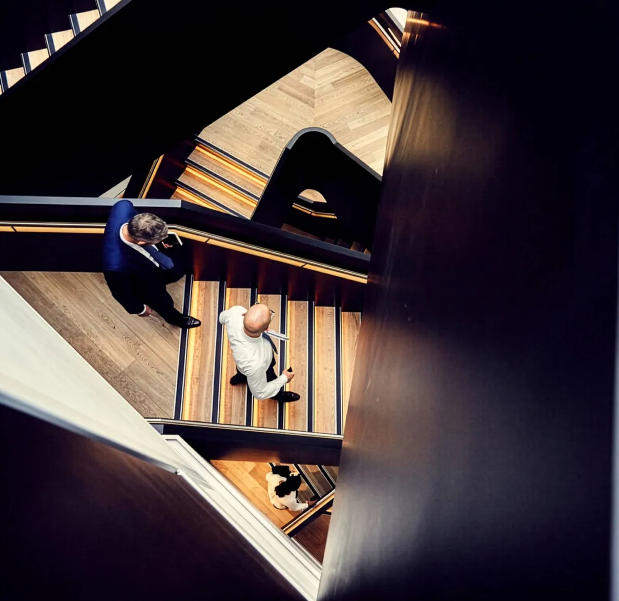 Looking down on Rathbones colleagues walking up and down a central stairwell in an office