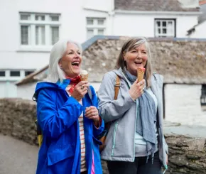 A picture of two ladies walking outside eating an ice cream