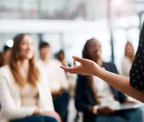 Person stood up speaking at an event in front of an audience