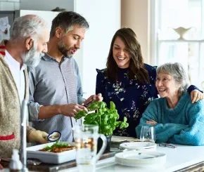 Multi-generational family laughing in the kitchen