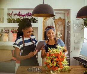 A younger and older woman working in a flower shop