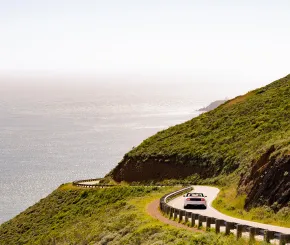 Car driving along coast of California