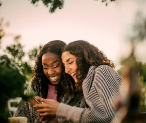Two friends smiling at phone