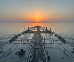Cargo ship on a calm sea, sailing into the sunset