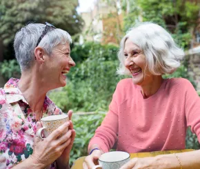 Two older ladies drinking tea and chatting