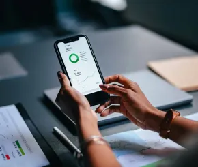 A woman uses a mobile phone with charts on it