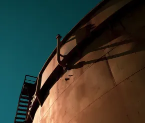 Industrial storage tank against a clear blue sky