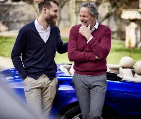 Two individuals in conversation beside a car, illustrating long‑term financial planning and the importance of preparing for retirement.